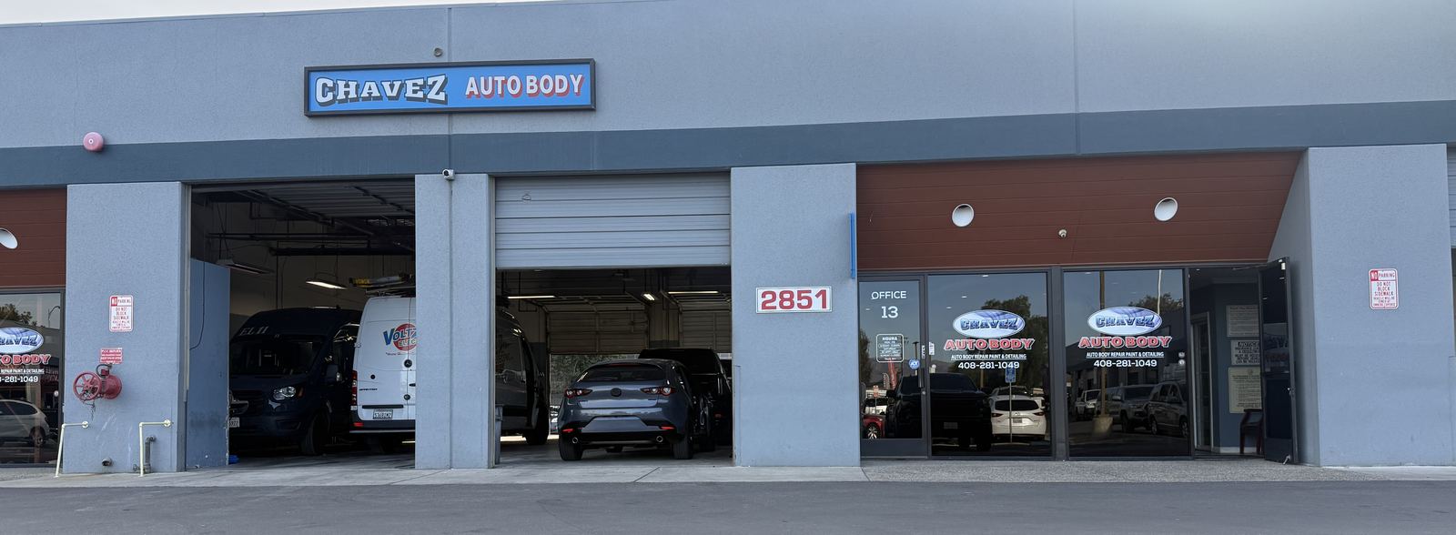 Chavez Auto Body building on Monterey Road with the blue Chavez Auto Body sign over the bays